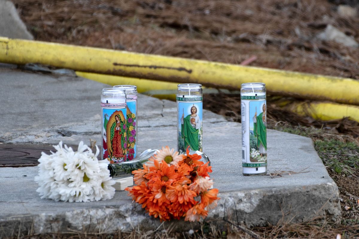 Candles and flowers are left along Centennial Drive near Foundation Food Group, Friday, Jan. 29, 2021, in Gainesville, Ga., in memory of the six that died from a nitrogen leak at the plant the day before. (SCOTT ROGERS)