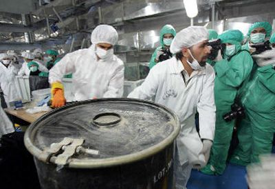 
Two technicians carry a container of uranium ore concentrate, known as yellowcake, at the Uranium Conversion Facility of Iran on Monday. 
 (Associated Press / The Spokesman-Review)