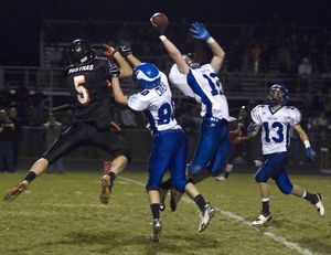 Coeur d'Alene's Joe Roletto knocks down a long pass intended for Post Falls' Jordan Pastras late in the second quarter at Post Falls High Friday night. Vikings Matt Lamber (80) and Kyler Dunn (13) assist in the defense. BRUCE TWITCHELL/ Special to The Spokesman-Review