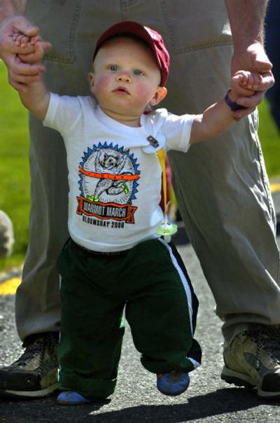 Kole Pettey, 11 months, gets help from his father, Jared Pettey,  while walking across the finish line during the inaugural Marmot March in Riverfront Park on Saturday. 
 (Holly Pickett / The Spokesman-Review)