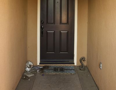 Trash and a fake rattle snake sculpture are seen on the front door of a home where police arrested a couple on Sunday accused of holding 13 children captive in Perris, Calif., Thursday, Jan. 18, 2018. (Damian Dovarganes / Associated Press)