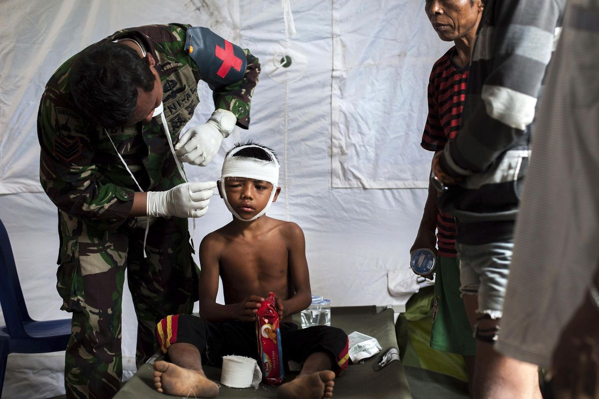 A military paramedic tends to a boy who suffers head injury from Sunday’s earthquake at a makeshift hospital in Kayangan, Lombok Island, Indonesia, Wednesday, Aug. 8, 2018. The north of Lombok has been devastated by the magnitude 7.0 quake that struck Sunday night, damaging thousands of buildings and killing more than 100 people. (Fauzy Chaniago / Associated Press)