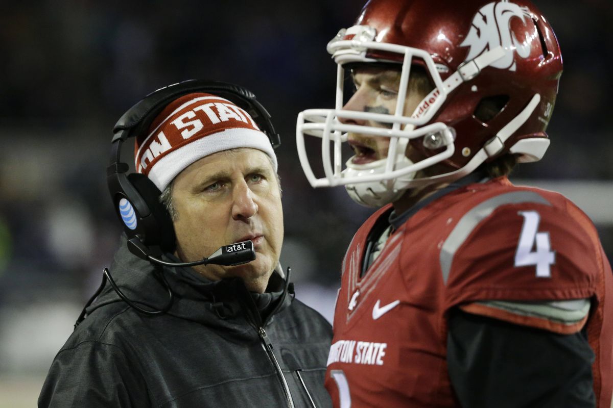 Washington State coach Mike Leach likes the personal approach to getting the ear of his players, as he did here last season with quarterback Luke Falk. (Associated Press)