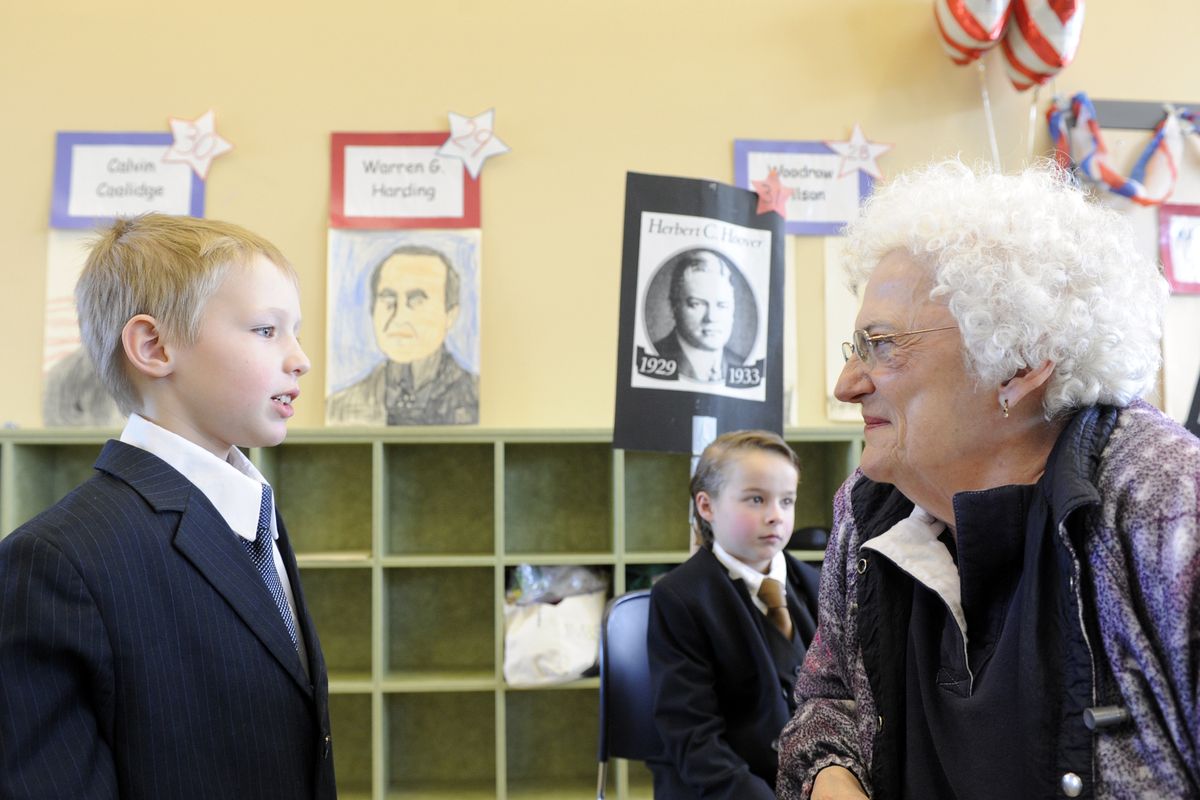 Marlene McCoy, right, listens to the presentation of Robert McNeilly, left, portraying Franklin Delano Roosevelt, Wednesday, at Freeman Elementary School. In the background is Taylor Jones portraying Herbert Hoover. After McNeilly’s presentation, McCoy said “I remember because I was alive when you were.” (Jesse Tinsley)