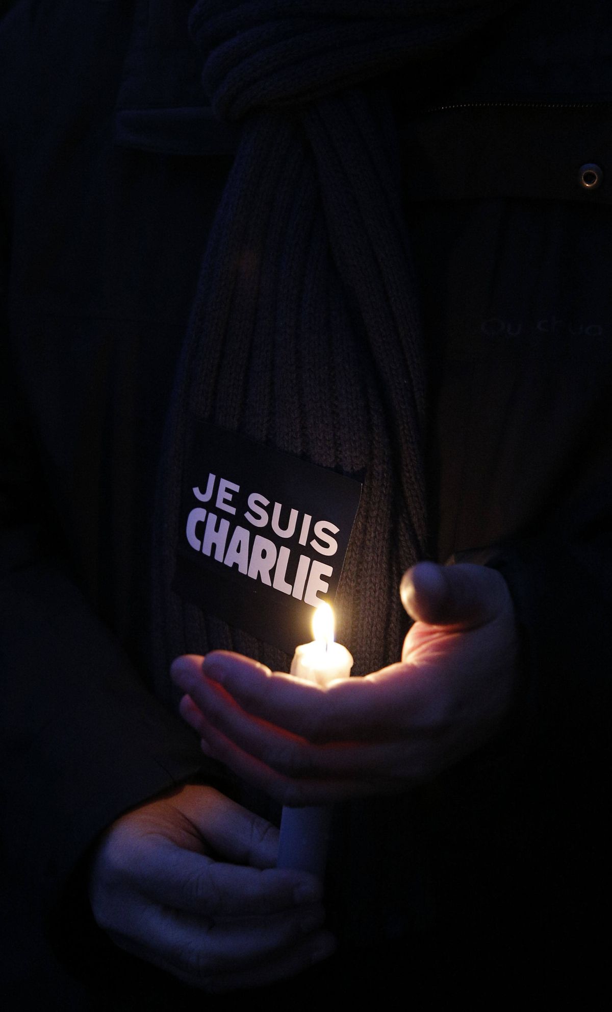 A man holds a candle and a sticker reading “I am Charlie” during a demonstration in Paris on Wednesday following the killings of 12 people at the offices of the satirical magazine Charlie Hebdo. (Associated Press)