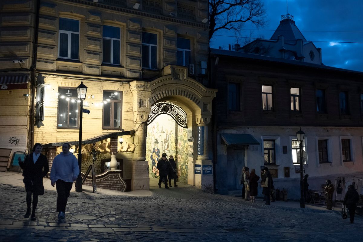 Pedestrians on the Andriivskyi Descent, an ancient cobblestone street in the heart of Kyiv on March 5, 2023. Ukraine has survived Russia’s all-out assault on its electrical grid thanks to prewar planning, new Western air defense systems, and deft problem solving by utility crews and engineers working long hours at great personal risk. (Emile Ducke/The New York Times)