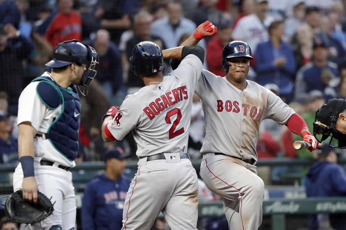 Boston’s Xander Bogaerts  is congratulated on his solo home run by Rafael Devers as Seattle Mariners catcher Mike Zunino stands nearby during the sixth inning Thursday in Seattle. (Elaine Thompson / AP)