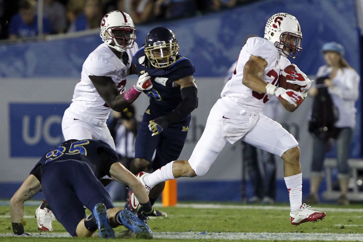 Stanford running back Kelsey Young, right, steps over an attempted tackle by UCLA’s Jordan Zumwalt. (Associated Press)