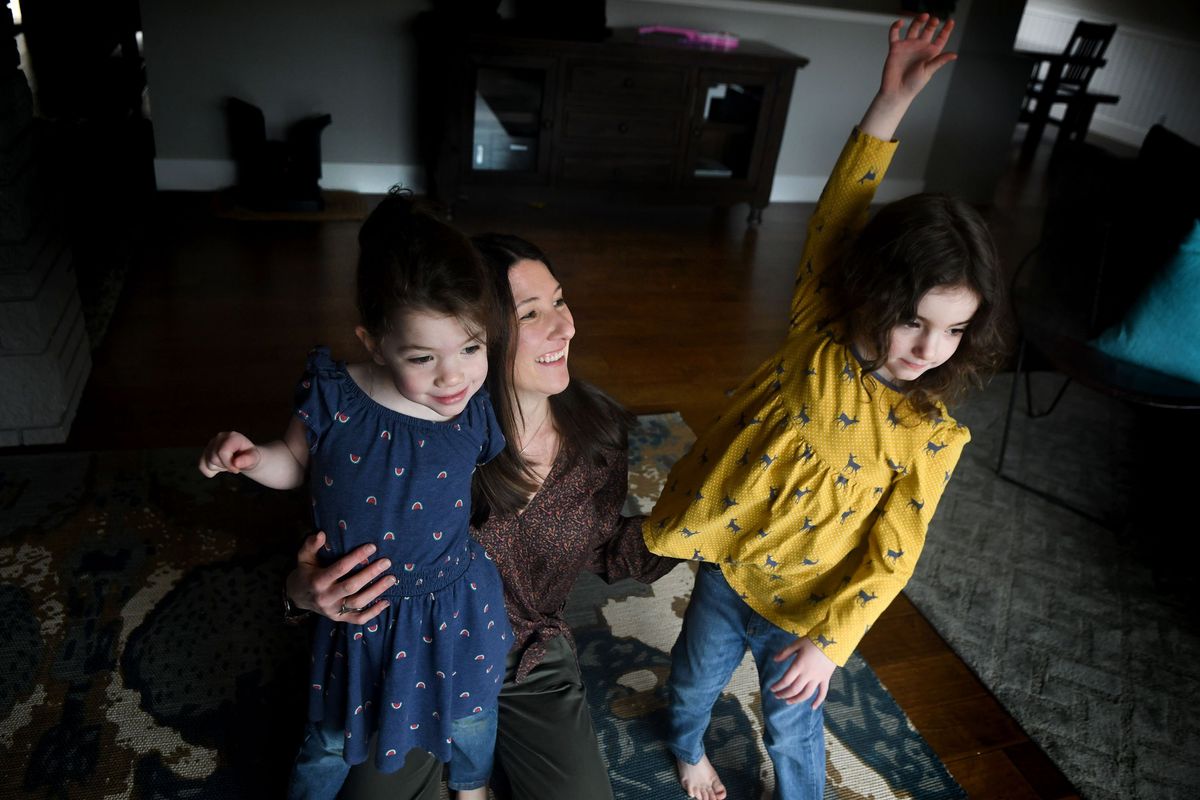 Sara Taylor is photographed with her twin daughters Charlee, left, and Claire at their home in Sandpoint on March 23. After her daughters were born prematurely in 2018, they spent the first 10 weeks of life at Providence Sacred Heart Children’s Hospital NICU. Now Taylor is giving back through an art series by creating fluid images to process what her family went through when the girls were born.  (Kathy Plonka/The Spokesman-Review)