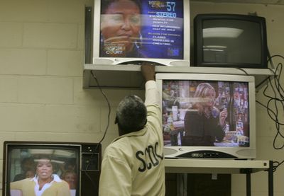 An inmate changes the channel as he joins others watching television in Columbia, S.C.  (Associated Press / The Spokesman-Review)
