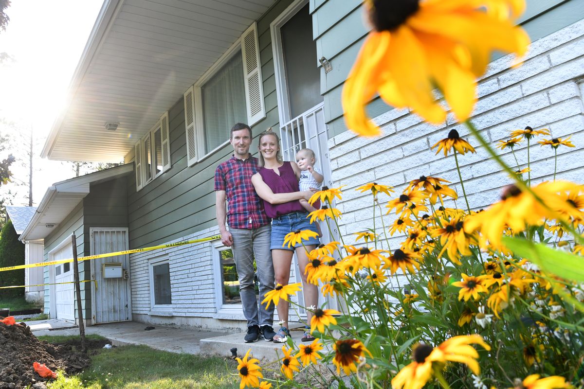 Brian Zaro poses for a photo with his wife Morgan and son Landon, 1, at their new home on the South Hill on Monday, July 22, 2019, in Spokane, Wash. The family is having renovations done to the home