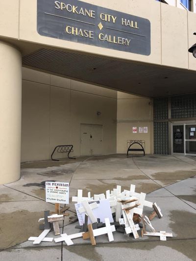A memorial with crosses for those who have died locally from COVID-19 at Spokane City Hall was vandalized after a protest against stay-home orders on Friday, according to the memorial’s organizer. (Tom Robinson)
