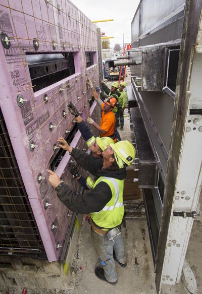 Workers with Oldcastle Precast build a module prison cell for a prison project in British Columbia. The cells are poured and finished in the Oldcastle yard and shipped north, where they are stacked three high per floor. (Colin Mulvany)