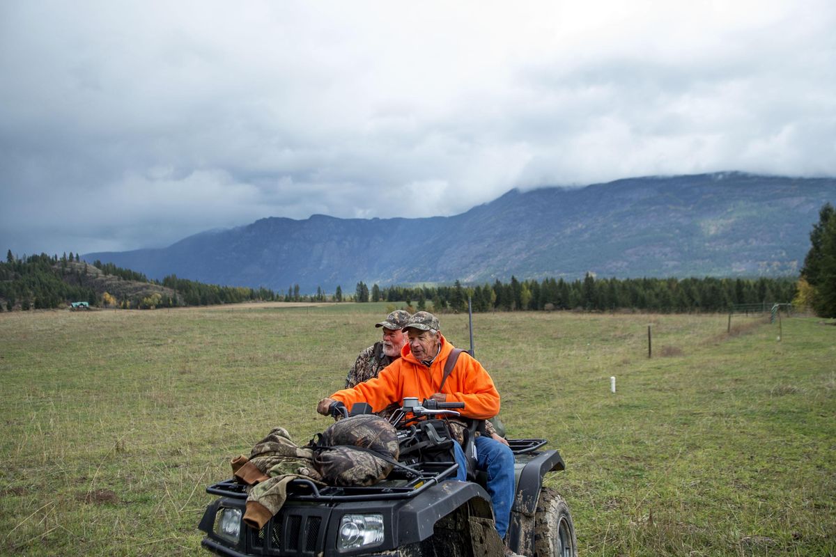 Vietnam veterans Dennis Ponsness, left, of Porthill, Idaho, and Dennis Place, of Saratoga, Florida, share an ATV ride  to a hunting location in Porthill on Friday, Oct. 14, 2016. Ponsness was the helicopter pilot who lifted Place to safety after being shot during the war. (Kathy Plonka / The Spokesman-Review)