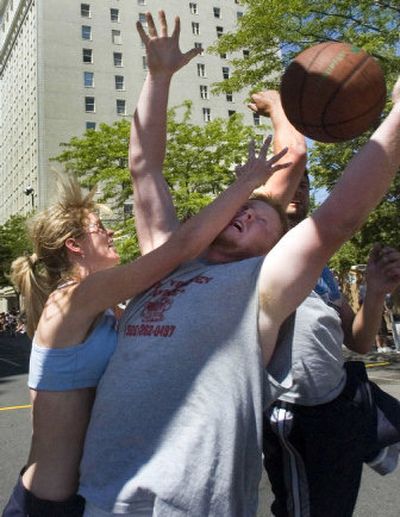 
Mandy Lewis of the Youstacoulds and Lonnie Edward of Mill Valley Homes struggle for control of a rebound during their coed game Saturday in downtown Spokane. The Youstacoulds won 11-8. 
 (Colin Mulvany / The Spokesman-Review)