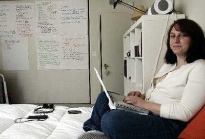 
Kristen Havens works at her bedroom office Monday at her apartment in the Hollywood section of Los Angeles. In spite of the potential pitfalls, there were almost 14 million Americans telecommuting at least part-time in 2004.  
 (Associated Press photos / The Spokesman-Review)