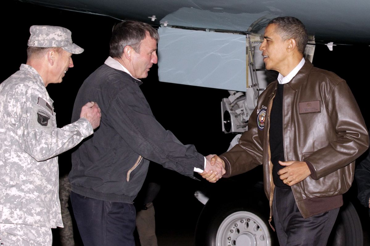 President Barack Obama is greeted by NATO Commander in Afghanistan Gen. David Petraeus, left, and US Ambassador to Afghanistan Karl W. Eikenberry, center, after stepping off Air Force One during an unannounced visit to Bagram Air Field in Afghanistan on Friday, Dec. 3, 2010. (Pablo Monsivais / Associated Press)