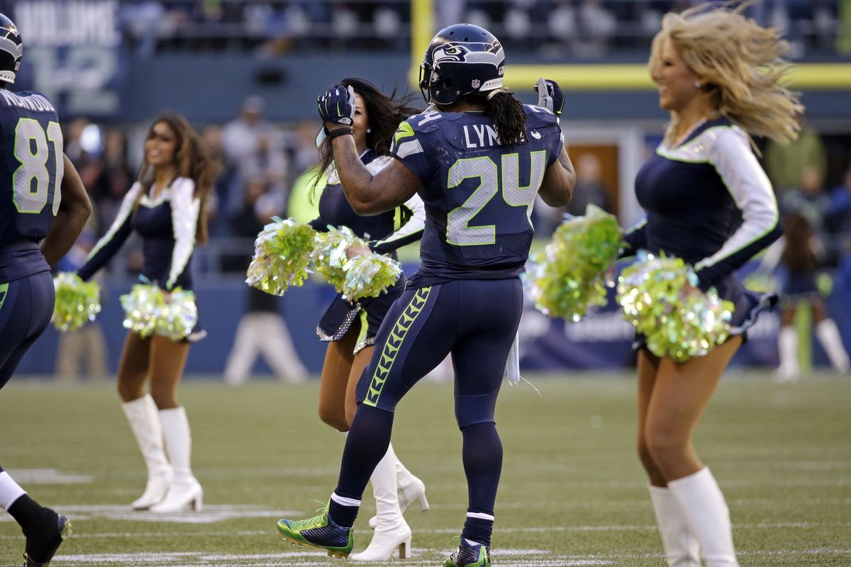 Marshawn Lynch joins in the fun with the SeaGals during a break in the action during second half. (Associated Press)