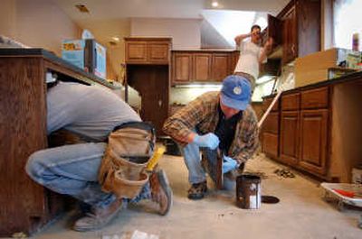 
Workers install new kitchen cabinets at the home of Joe and Linda Rank in Austin, Texas. Kitchens are among the most important areas of the home to spend some money upgrading before selling.
 (AP / The Spokesman-Review)