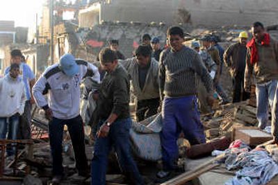 
Residents on Thursday remove the body of a victim  of a magnitude 8.0 earthquake that hit the area late Wednesday in the town of Pisco, Peru. Virtually all of the town sustained damage, and its hospitals were destroyed. Associated Press photos
 (Associated Press photos / The Spokesman-Review)