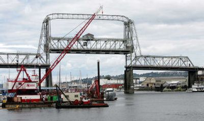 
The 94-year-old Murray Morgan Bridge is seen Wednesday, in Tacoma, stuck in the up position after opening for the Tall Ships Festival a week before. Repair efforts would put crews within arm's reach of a pair of fledgling peregrine falcons, and state Department of Transportation workers don't want to disturb them. 
 (Associated Press / The Spokesman-Review)