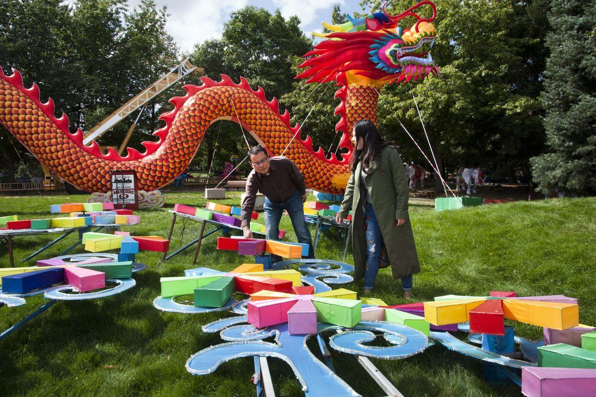 Sam Song, assistant director of Riverfront Park, and Jessie Li, representative for Sichuan Tianyu, view the display of a windmill and the 196-foot dragon for the Chinese Lantern Festival on Wednesday in Riverfront Park. The festival runs Sept. 26 through Nov. 1. (Dan Pelle)