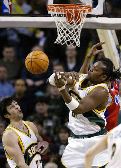 
Seattle's Danny Fortson tries to get a handle on a rebound as Vladimir Radmanovic looks on Tuesday night.
 (Associated Press / The Spokesman-Review)
