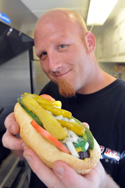 Curtis Bytnar of Big Red’s dresses up a Chicago-style in his hot dog trailer at Sunset Boulevard and Government Way. Starting with a hot dog fried until it’s brown and crunchy, he adds mustard, tomatoes, cucumber slices, relish, onions, peppers and a dill pickle spear. (Jesse Tinsley)