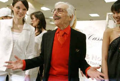 
Designer Oleg Cassini, center, jokes around as he poses for photographs with models wearing outfits from his latest collection at Lord & Taylor's celebration of the 50th anniversary of Cassini's first windows on New York's Fifth Avenue, at Lord & Taylor in New York.
 (Associated Press photos / The Spokesman-Review)