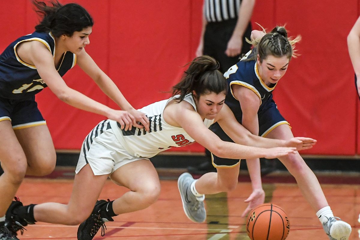 Ferris’ Elliot Hencz, center takes on Mead’s Teryn Gardner, right and Teayona Hoard, left, during a scramble for a loose ball, Wednesday, Jan. 5, 2022 at Ferris.  (Dan Pelle/THE SPOKESMAN-REVIEW)