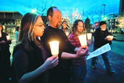 
From left to right,  Rachel Nevins, 17, her father, Tim, and brother, Zachary, 14, sing during a candlelight vigil marking the fourth anniversary of the start of the war in Iraq. About 200 hundred people took part in the Monday evening protest sponsored by MoveOn.org. 
 (Colin Mulvany / The Spokesman-Review)