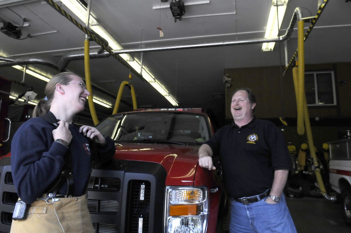 Keri Burden, left, jokes with Cheney Fire Chief Mike Winters in the engine bay Thursday. Burden is the first female resident firefighter at the Cheney Fire Department and a student at Eastern Washington University. (Jesse Tinsley / The Spokesman-Review)
