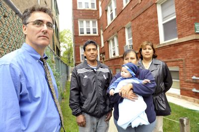 Cook County Sheriff Tom Dart, left, stands with tenants of a foreclosed apartment building in Chicago. Last week, Dart stopped sending deputies on court-ordered foreclosure evictions.  (Associated Press / The Spokesman-Review)