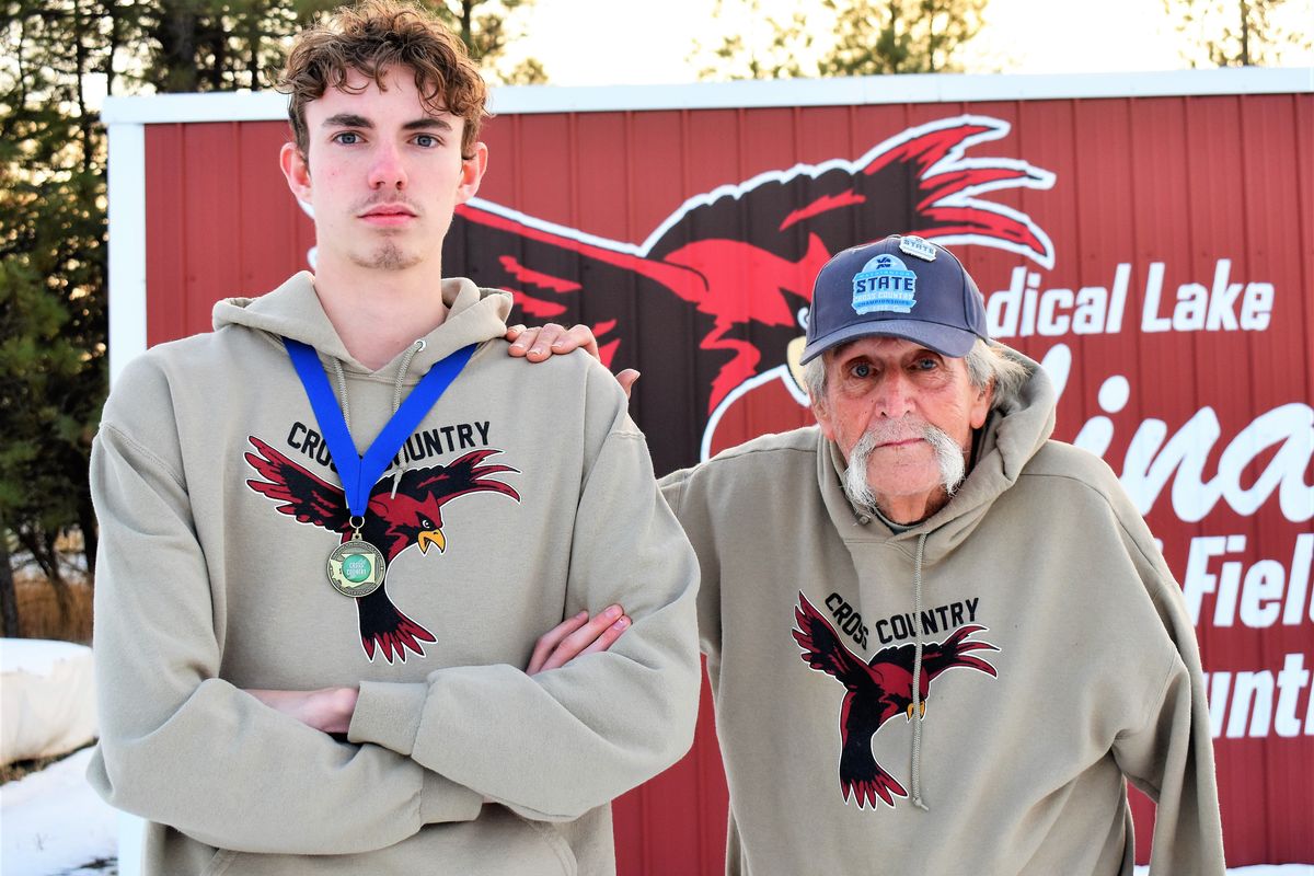 Medical Lake runner Reid Headrick and coach Gene Blankenship pose for a photo with Headrick