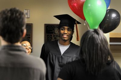 Marcus Fletcher, center, celebrates with family and friends after receiving his high school diploma Thursday night at the Spokane Public Schools Administration Building boardroom. Five young men from Rogers and LC got their diplomas midyear.  (Jesse Tinsley / The Spokesman-Review)