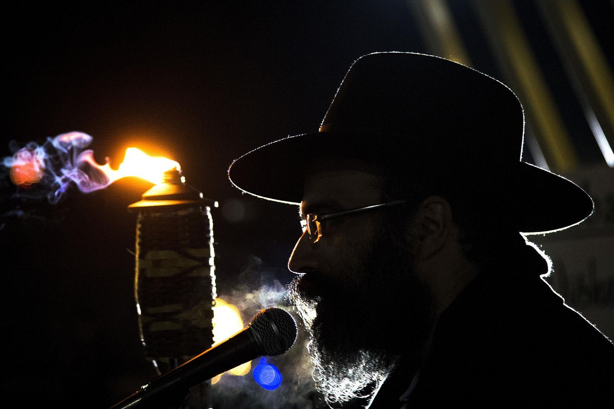 Before lighting a large menorah, Rabbi Yisroel Hahn speaks to the crowd gathered in Riverfront Park on Sunday. The Chabad of Spokane County community center presented the event in celebration of the eight-day Jewish Hanukkah holiday that began on the evening of Dec. 6. (Colin Mulvany / The Spokesman-Review)