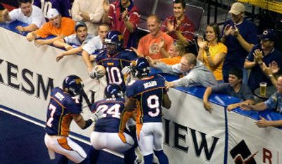 
Spokane Shock fans and teammates swarm Charles Frederick after he returned the opening kickoff 57 yards for a touchdown Saturday night at the Arena. 
 (Christopher Anderson / The Spokesman-Review)