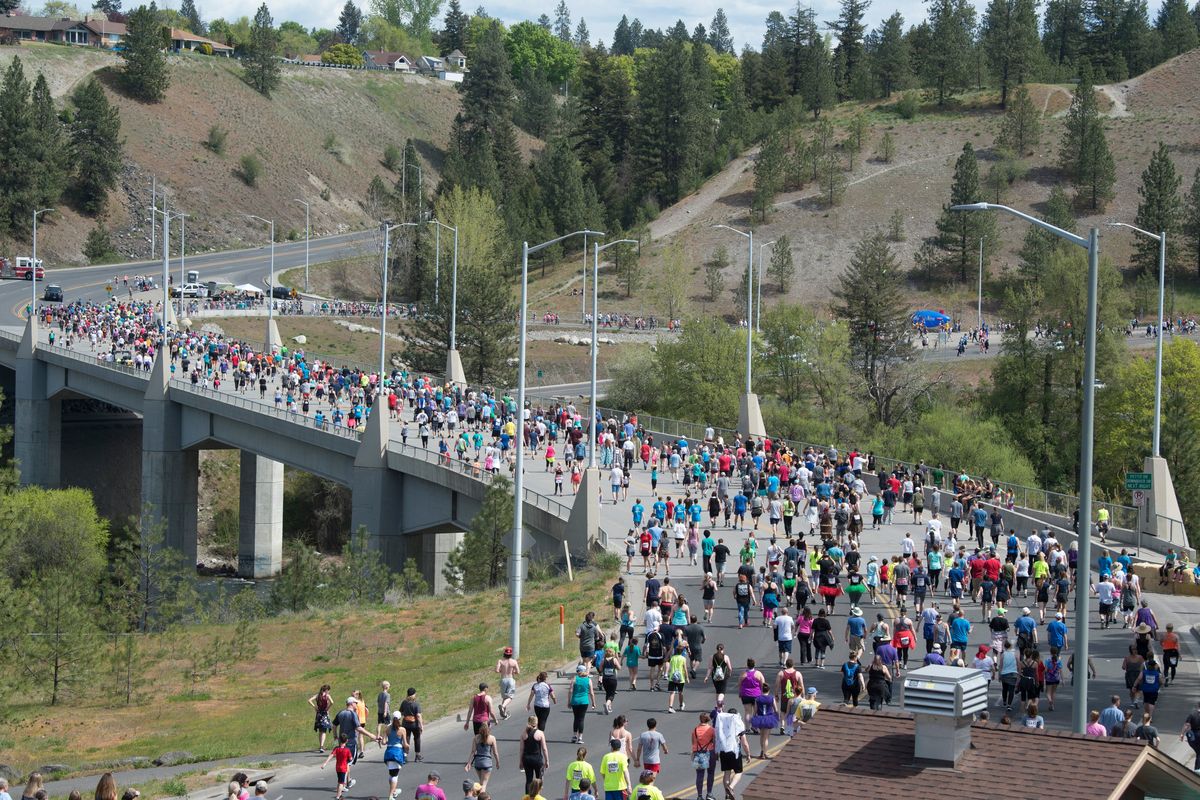 The Bloomsday throng makes its way down to the T.J. Meenach Bridge over the Spokane River in 2019 before turning up Pettet Drive, also known as Doomsday Hill. T.J. Meenach Drive on the north side of the river will close March 13 and is expected to remain closed through August for work on the Cochran Basin stormwater project.  (By Jesse Tinsley/THE SPOKESMAN-REVIEW)