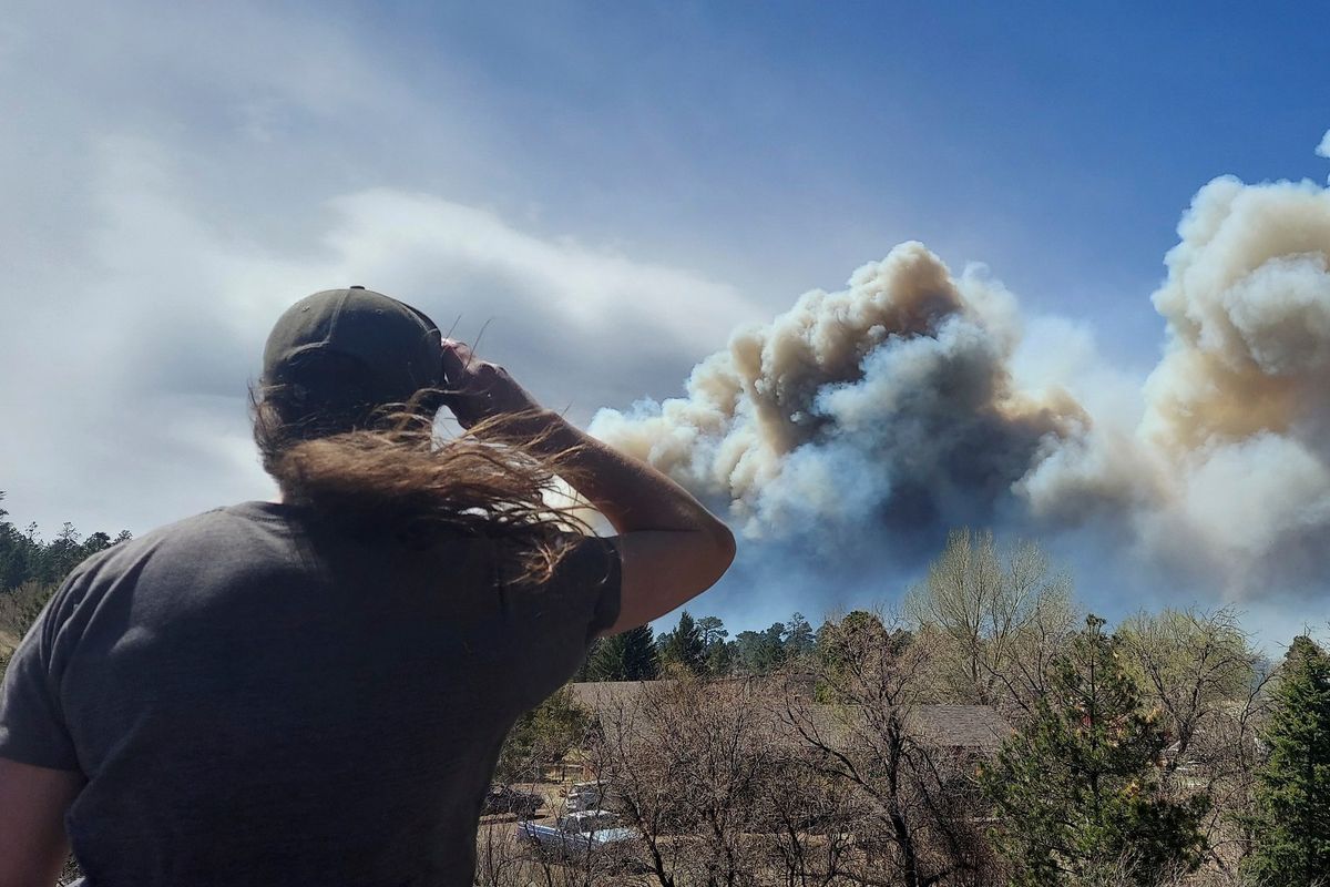 Smoke from a wind-whipped wildfire rises above neighborhoods on the outskirts of Flagstaff, Arizona, on Tuesday, April 19, 2022. Authorities issued evacuation orders for a couple hundred homes.  (Sean Golightly)