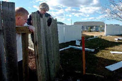 
Phil and Patti Perr examine the damage after a man  police identified as William E. Pfaff grazed their fence after smashing through a neighbor's vinyl fence, at right, along Atlas Road in Coeur d'Alene. 
 (Jesse Tinsley photos/ / The Spokesman-Review)