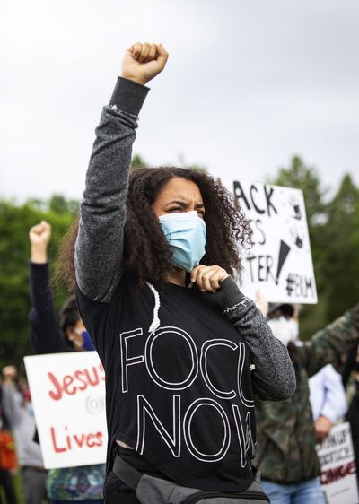 Mya Montgomery gives the Black Power sign as she peacefully protests in Riverfront Park's Lilac Bowl in Spokane, Wash. on Sunday, June 7, 2020. The protest was held to remember Breonna Taylor, an African American woman was fatally shot in Louisville, Ky., by police in her own home in March, as well as to call for change against systemic racism and police brutality. (Libby Kamrowski/The Spokesman-Review via AP) ORG XMIT: WASPO704  (Libby Kamrowski)