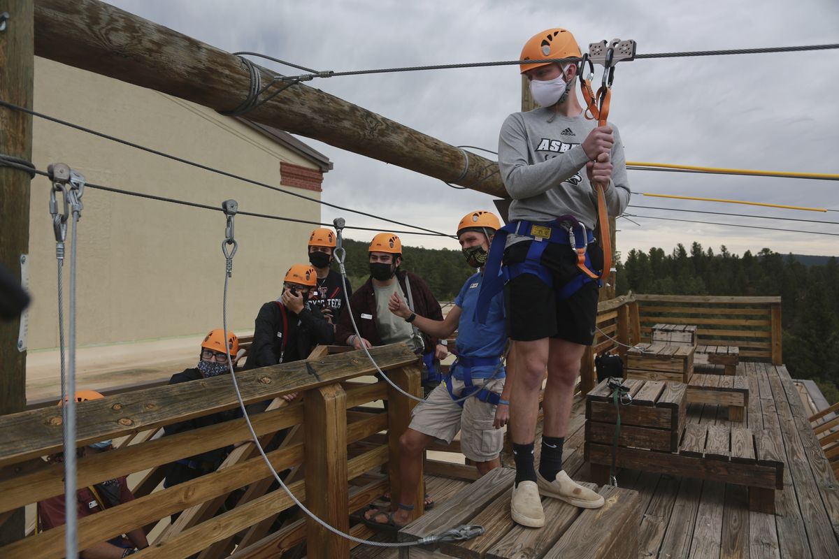 Glorieta Adventure Camp counselor Kole Linville, of Kentucky, trains on a zip line on Friday, May 21, 2021, in Glorieta, N.M., before campers arrive. The 3,000-bed camp outside Santa Fe opened up at a third of its normal capacity under pandemic restrictions after being closed last year. Campers and staff will be kept in pods of 10 or less, wear masks outside their sleeping quarters, and eat outdoors to prevent outbreaks. (Cedar Attanasio)