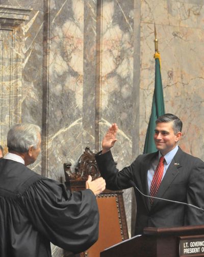 State Supreme Court Justice Tom Chambers congratulates Sen. Mike Baumgartner after swearing him in. (Jim Camden/The Spokesman-Review)