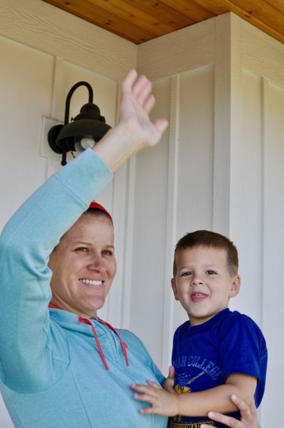 Julia Ditto happily waves goodbye to her kids on their first day of school in 2018, with the ever-present child still on her hip.  (Julia Ditto/For The Spokesman-Review)