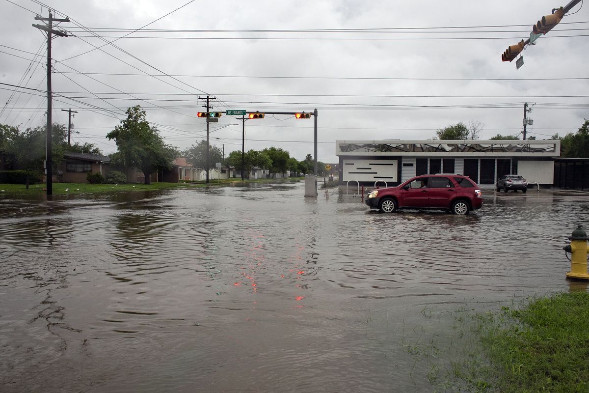 A driver waits at a stoplight at a flooded intersection, Wednesday, May 19, 2021, in Brownsville, Texas. The National Weather Service is warning that more rain is expected in Louisiana, Texas, Oklahoma and Arkansas through at least Thursday, adding to this week