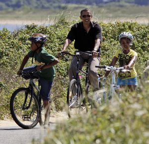 ORG XMIT: MAAB103 President Barack Obama, second from left,  pauses on his bike ride with his family and friends including Sasha Obama, 8, right, while on vacation on Martha's Vineyard on Lobsterville Beach in Aquinnah, Mass. Thursday, Aug. 27, 2009.(AP Photo/Alex Brandon) (Alex Brandon / The Spokesman-Review)
