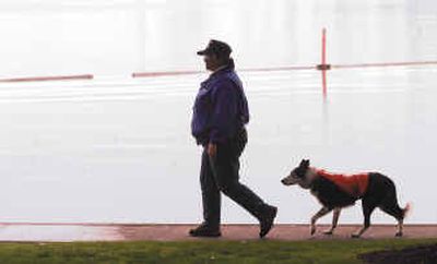 
Lynn Kalnoski, owner of Kalcade Geese Police, and Troy, one of her dogs, patrol the swimming beach for geese at Gene Coulon Park in Renton, Wash. Kalnoski patrols beaches daily in Renton and Bellevue and less frequently at Juanita Beach Park in Kirkland. The improvement is most noticeable at Gene Coulon Park, where at one time up to 300 geese a day lounged on the grass and in the water. They destroyed large tracts of grass the city had to replace.
 (Associated Press / The Spokesman-Review)