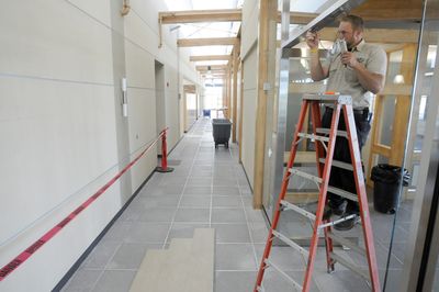 Kris Campbell with Allied Fire and Security, installs access controls to doors at the front entrance of the new Inland Power and Light Co. headquarters building on West Plains on Monday. The building replaces a 55-year-old structure on East Second Avenue in downtown Spokane. (Colin Mulvany / The Spokesman-Review)