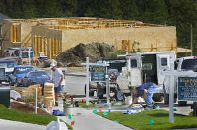 
Construction workers swarm a street in the new River Run development getting homes ready for purchase.
 (The Spokesman-Review)
