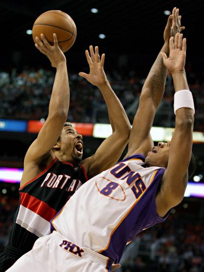 Portland’s Andre Miller, left, shoots over Suns’ Channing Frye.  (Associated Press)